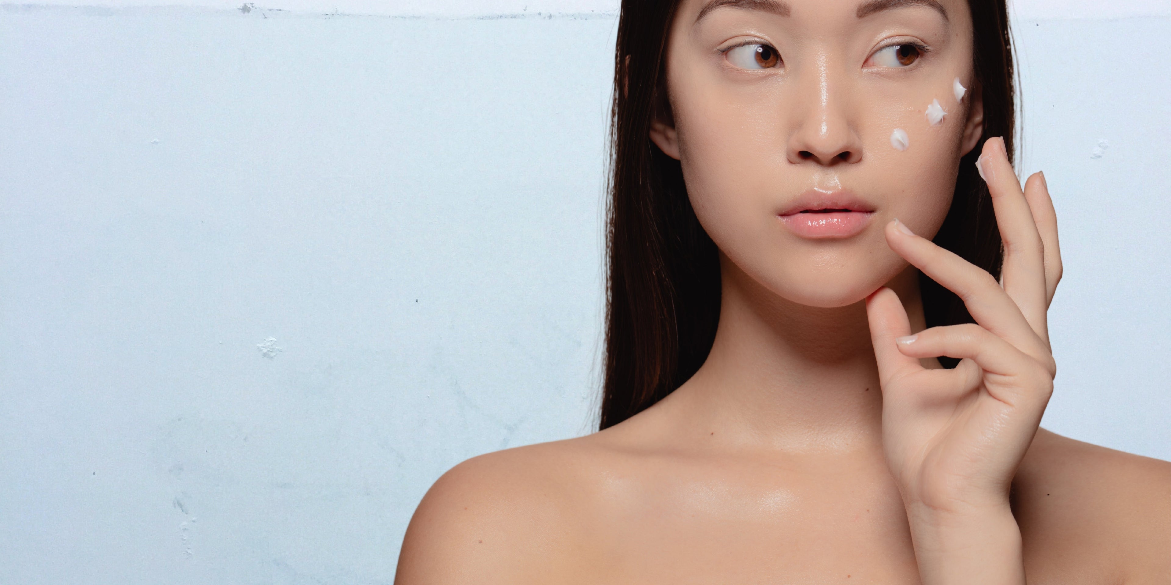 une femme asiatique avec une crème sur son visage