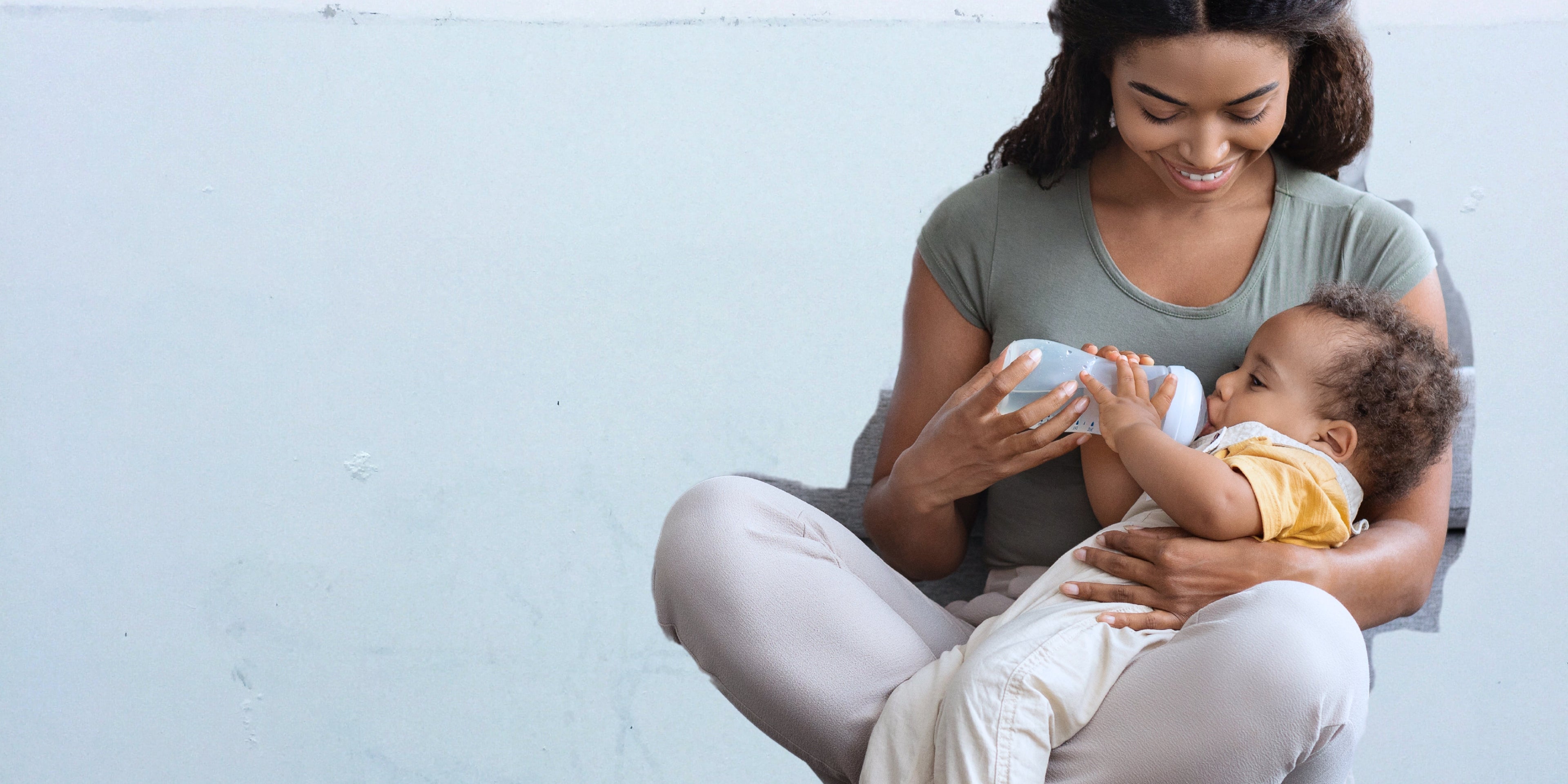 une femme noire qui est en train de nourrir son bébé
