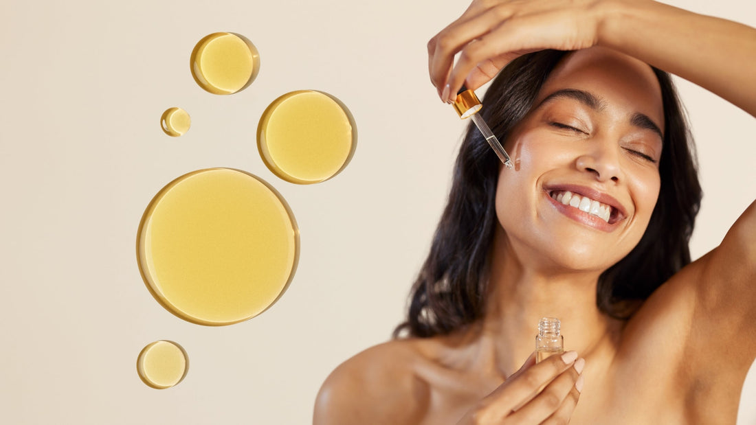 Une femme souriante qui est en train d'appliquer des huiles sur son visage.