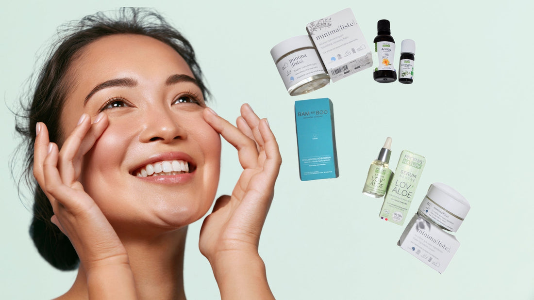 Une femme souriante qui touche ses joues, à côté des produits de beauté bio dans un emballage en verre; sur un fond vert clair.